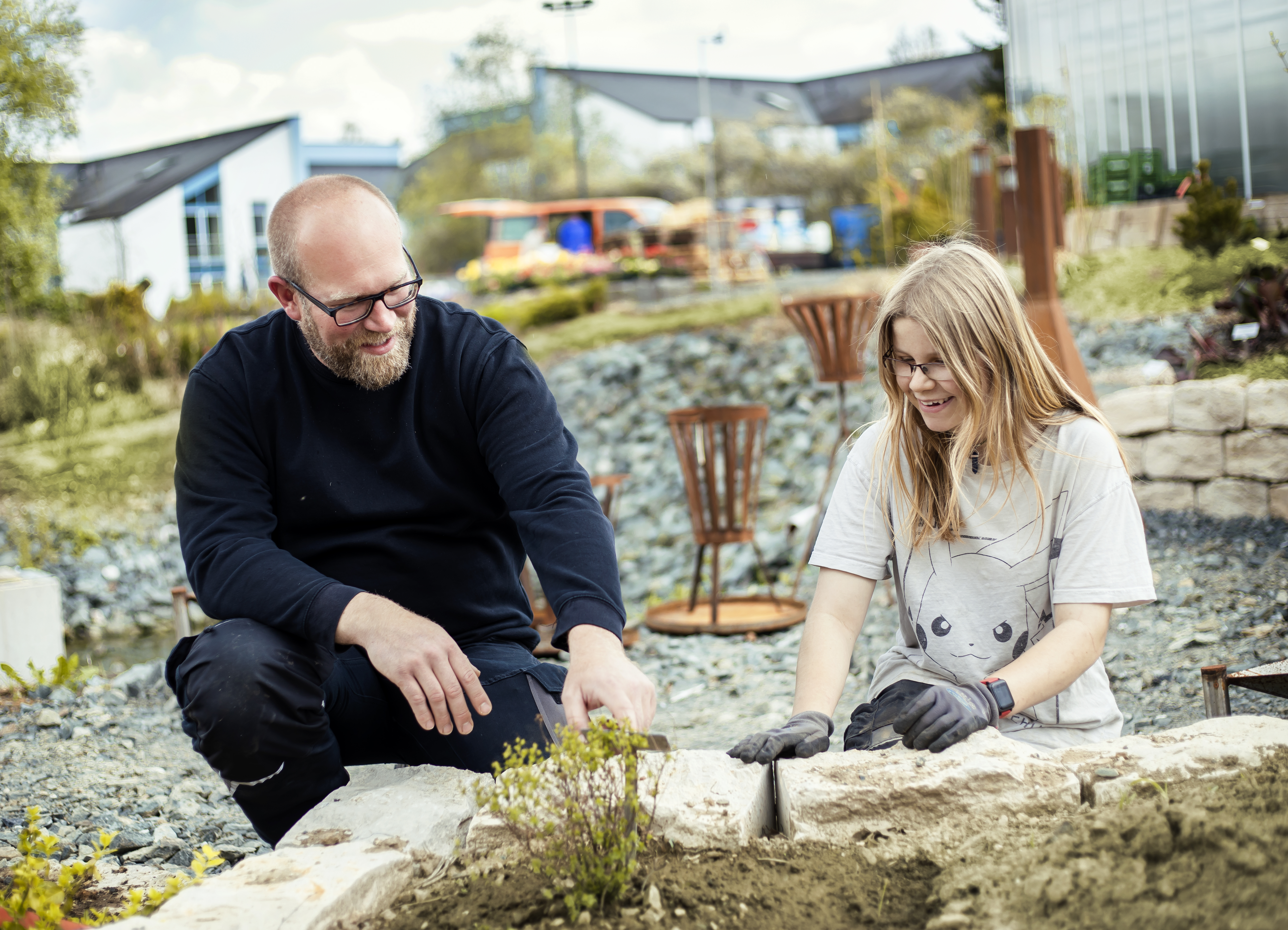 Eine junge Frau und ein Mann arbeiten im Garten