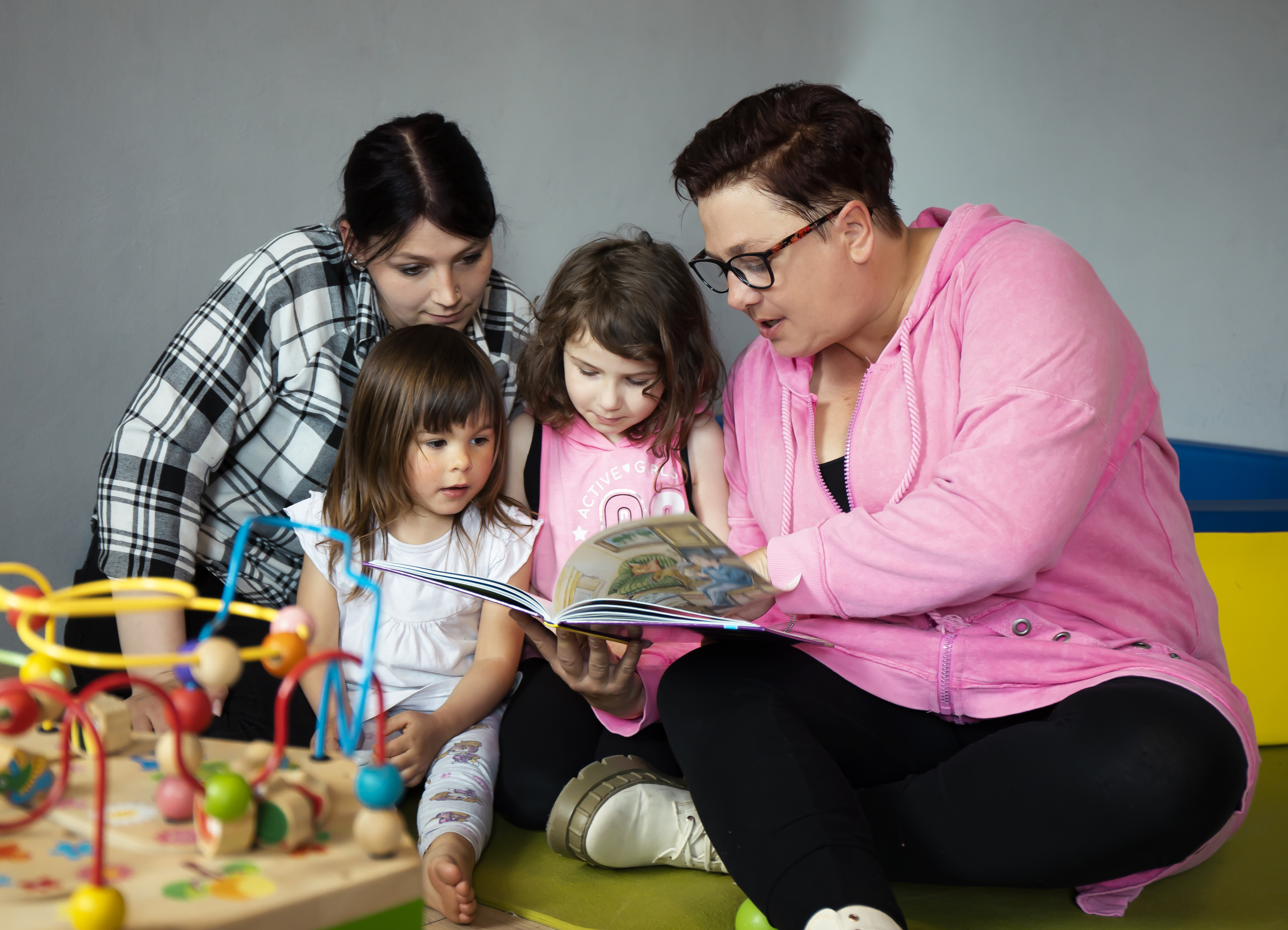 Zwei Frauen lesen Kindern etwas vor